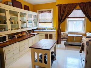 a kitchen with white cabinets and a table in it at Bluebird Guesthouse in Portland