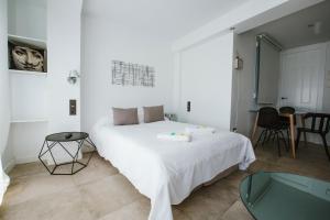a bedroom with a white bed and a glass table at Reyes 59 in Granada