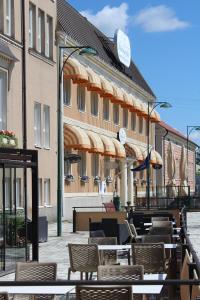 un restaurant avec des tables, des chaises et des parasols dans l'établissement Pietarsaaren Kaupunginhotelli, à Pietarsaari