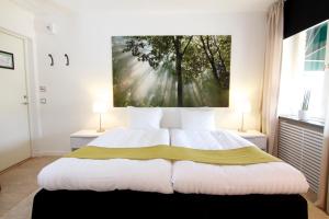 um quarto com uma cama com um quadro na parede em Hotell Tinget em Sala