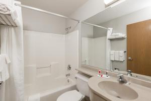 La salle de bains est pourvue d'un lavabo, de toilettes et d'un miroir. dans l'établissement Microtel Inn & Suites by Wyndham Sioux Falls, à Sioux Falls 30 autres photos