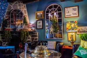 a room with a couch and a table and windows at Hotel Boutique Balaitus in Sallent de Gállego