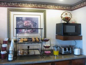a kitchen with a counter with a microwave and some food at Executive Inn and Suites - Jackson in Jackson