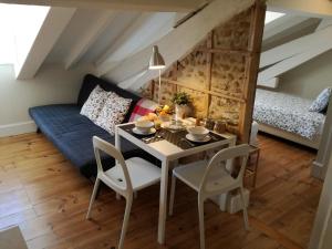 a living room with a table and a couch at Ah33 - Estúdios in Coimbra