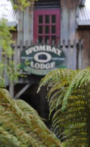 um sinal para um alojamento de turismo selvagem com plantas em The Wombat Cottage em Tullah