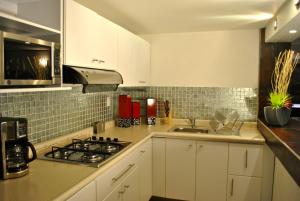 a kitchen with a sink and a stove top oven at Business Suites SG in Mexico City