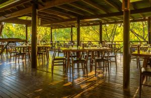 un grupo de mesas y sillas en una terraza de madera en The Station at El Questro en Kununurra