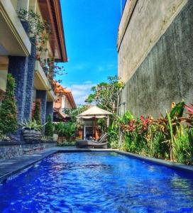 a swimming pool in the middle of a building at Agus Tri Homestay in Sanur