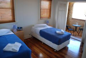 a bedroom with two beds and a table and chairs at Accommodation Sydney Rockdale in Sydney