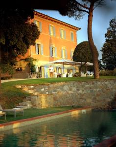 a building with a swimming pool in front of a house at Fontelunga Hotel & Villas in Pozzo