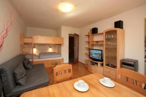 - un salon avec une table et des lits superposés dans l'établissement Appartement René, à Zell am See