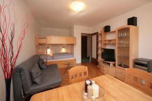 salon ze stołem i łóżkiem piętrowym w obiekcie Appartement René w mieście Zell am See
