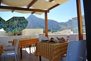a patio with two tables and a view of a mountain at Hotel Il Melograno in San Vito lo Capo