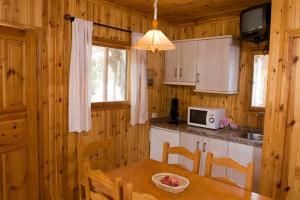 a kitchen with a dining table and a microwave at Camping Orgiva in Órgiva