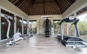 a gym with several treadmills and elliptical machines at Sudamala Resort, Seraya, Flores in Labuan Bajo