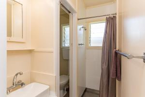 a bathroom with a toilet and a sink and a mirror at Waitangi Beach Bach 30A in Paihia