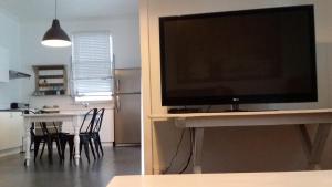 a living room with a television and a table with chairs at Verandah Motel in Gympie