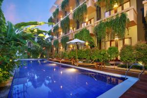 a swimming pool in the middle of a building at Bali Chaya Hotel Legian in Legian