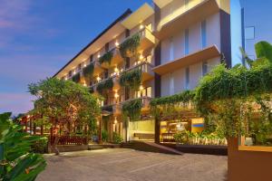 an exterior view of a building with plants at Bali Chaya Hotel Legian in Legian