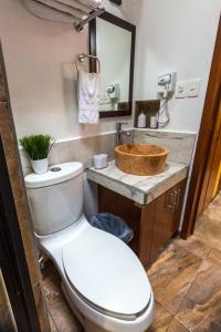 a bathroom with a toilet and a sink at Merida Serviced Apartments in Mérida