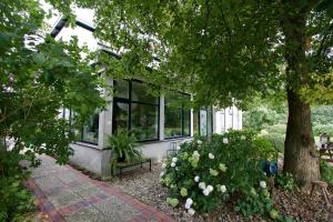 a building with a bench and flowers in front of it at de Witte Wolk in Nieuw-Scheemda