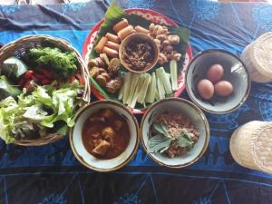 a table with plates of food and bowls of food at Hug Her Him Nan in Nan