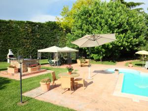patio con tavolo e ombrellone accanto alla piscina di Villa Paolotti by Interhome a Bettona
