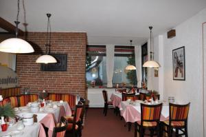 une salle à manger avec des tables, des chaises et un tissu de table rose dans l'établissement Landhaus Dürkop, à Wolfenbüttel