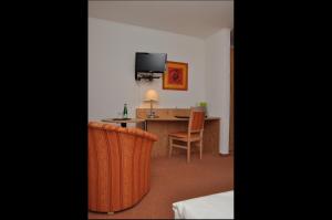 a room with a desk with a television and a chair at Landhaus Dürkop in Wolfenbüttel