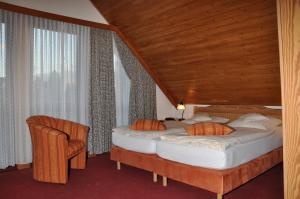 two beds in a room with a wooden ceiling at Landhaus Dürkop in Wolfenbüttel