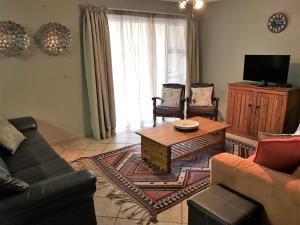 Una sala de estar con un sofá y una mesa de café. en Sand & Sea Self-Catering Apartments, en Swakopmund