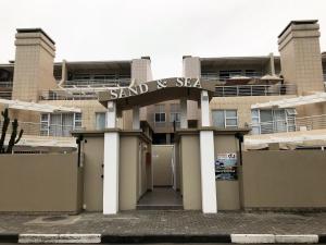 un edificio con un cartel que lee arena y esquí en Sand & Sea Self-Catering Apartments, en Swakopmund