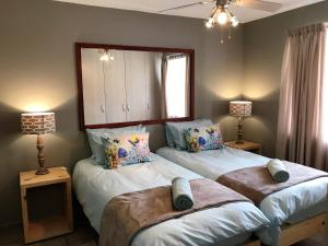 1 dormitorio con 2 camas, 2 lámparas y una ventana en Sand & Sea Self-Catering Apartments, en Swakopmund