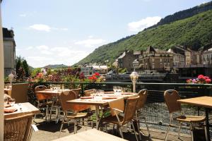 un restaurant avec des tables et des chaises sur un balcon dans l'établissement Logis Central Hôtel & Spa, à Bort-les-Orgues