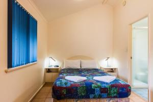 a bedroom with a bed and two lamps and a window at Riverview Tourist Park in Margaret River Town