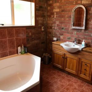 a bathroom with a bath tub and a sink at Hall on the Terrace in Temuka
