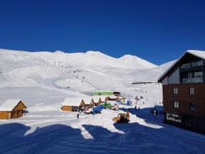 a snow covered mountain with a ski lodge and a ski slope at Gudauri Redco Block 4/304 in Gudauri