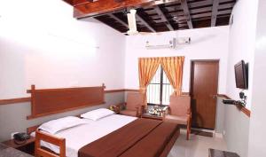 a bedroom with a large bed and a television at The Boat Jetty Bungalow in Cochin
