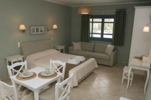 ein Wohnzimmer mit einem Bett, einem Tisch und einem Sofa in der Unterkunft Boutique Hotel Iasmos in Trizonía