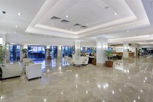 een lobby met witte stoelen, tafels en ramen bij Sunis Elita Beach Resort Hotel & SPA in Kizilagac