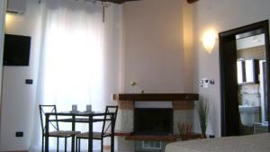 ein Wohnzimmer mit einem Kamin, einem Tisch und Stühlen in der Unterkunft B&B al Castello Torremaggiore in Torre Maggiore