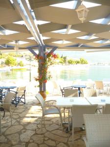 a restaurant with tables and chairs and a view of the water at Boutique Hotel Iasmos in Trizonía