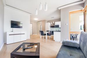 salon z kanapą i stołem w obiekcie Apartamenty Sun & Snow Mila Baltica w Gdańsku +16 zdjęć