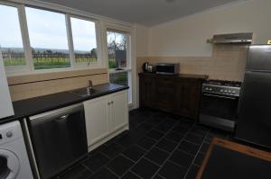 uma cozinha com um lavatório e um fogão em Peppermint Farm Cottage em McLaren Vale