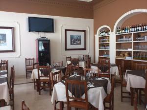 a restaurant with tables and chairs and a flat screen tv at Hotel Mirador in Algeciras