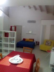 a living room with a red table and a blue bed at Casa Maddò in Castelbuono