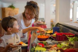 een vrouw en een kind die eten bereiden in een keuken bij VTF Les Esquirousses in Arvieux