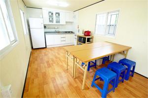慶州的住宿－Dobong Seodang，厨房配有木桌和蓝色凳子