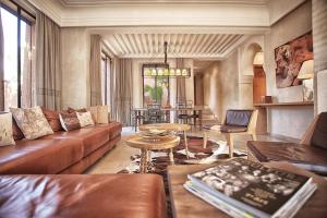 a living room with a couch and a table at Lankah - Authentic villa with private heated pool close to city center in Douar Caïd Layadi