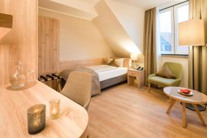 ein Hotelzimmer mit einem Bett und einem Tisch in der Unterkunft Hotel Altes Zollhaus in Horumersiel